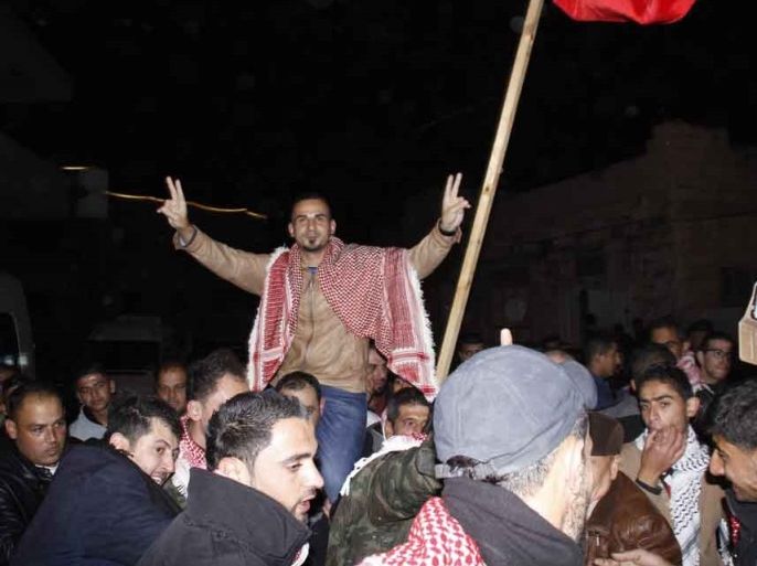 فلسطينيون يحملون الأسير المحرر بلال كايد على الأعناق خلال استقباله في بلدة عصيرة قرب نابلس بالضفة الغربية