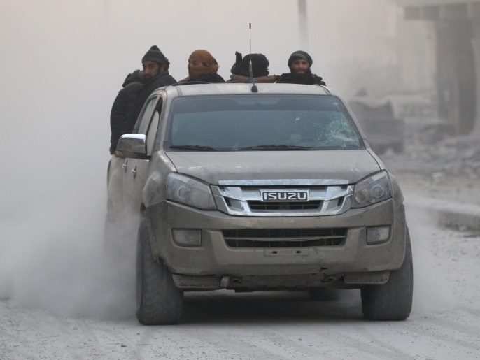 مقاتلون من المعارضة في سيارة بأحد أحياء حلب الشرقية (رويترز)