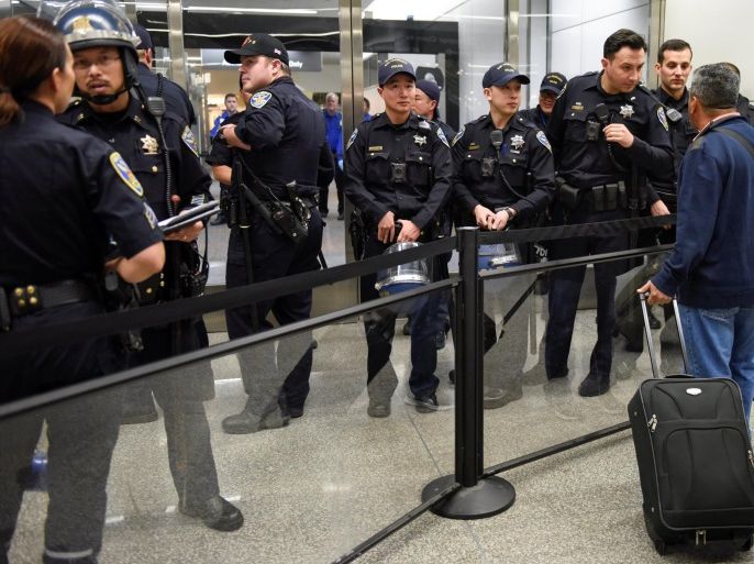 Police redirect travelers after the security check point was closed due to protests in Terminal 4 at San Francisco International Airport in San Francisco, California, U.S., January 28, 2017. REUTERS/Kate Munsch
