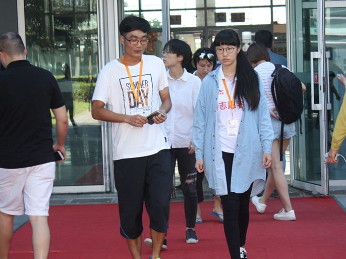 شباب صينيون يسيرون في مجمع للشركات الخاصة