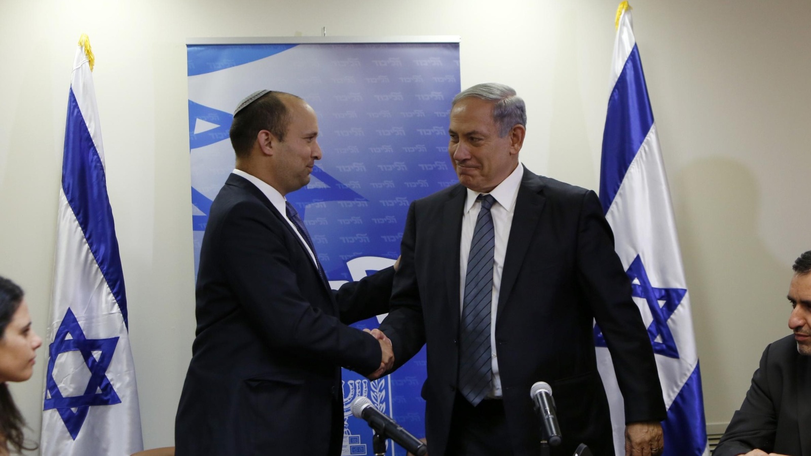 ‪(غيتي)‬ زعيم حزب البيت اليهودي نفتالي بينيت (يسار) يصافح رئيس الوزراء بنيامين نتنياهو
