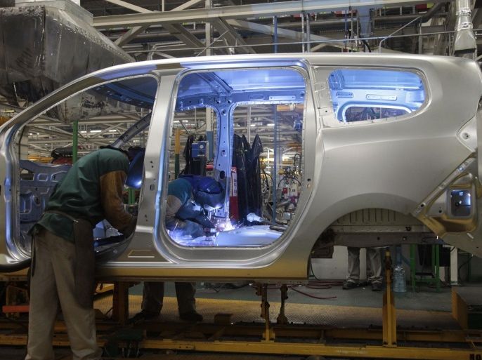 Employees work on a vehicle at the assembly line of Dacia Sandero cars at a factory operated by Somaca in Tangiers, February 21, 2013. Somaca is part of an expanding web of car makers and parts suppliers in Morocco, a heavily agricultural country which hopes to use the auto sector to expand its industrial base. A strong auto industry, exporting cars to Europe, North Africa and further afield, could help to resolve one of the country's main economic weaknesses, its exte