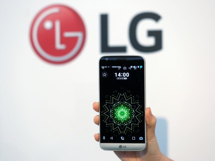 A model poses for photographs with LG Electronics' new smartphone G5 during its launch event in Taipei, Taiwan March 24, 2016. REUTERS/Tyrone Siu/File Photo
