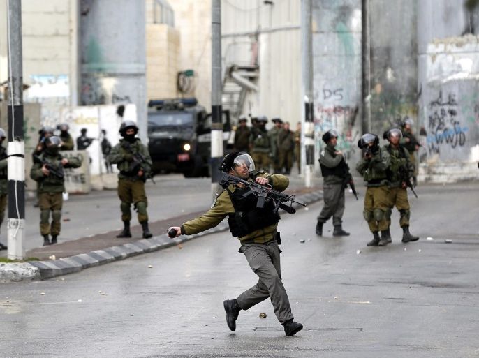 An Israeli border policeman throws a tear gas grenade against Palestinians during clashes following a protest at checkpoint 300 in the West Bank city of Bethlehem, 26 January 2017. Palestinians organized a protest at the northern entrance of the West Bank city of Hebron which connects Bethlehem to Jerusalem calls to retrieve bodies of alleged assailants held by the Israeli army.