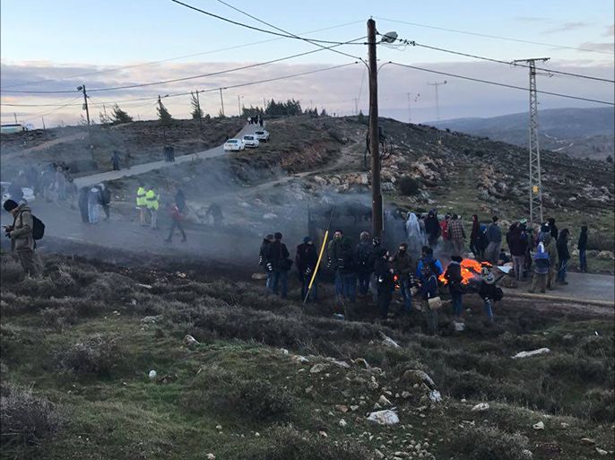 مستوطنون يضرمون النيران عند مدخل البؤرة الاستيطانية "عمونا" التي تقرر إخلاءها من المحكمة العليا الإسرائيلية، قضاء رام الله، شباط/فبراير 2017.
