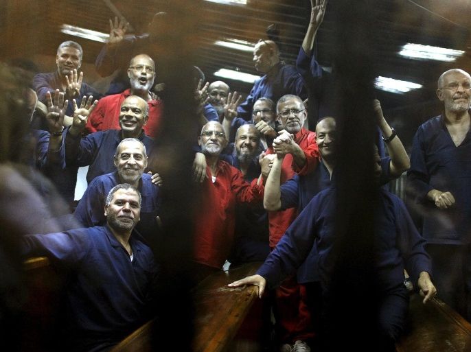 Muslim Brotherhood members including the general guide of the Muslim Brotherhood, Mohamed Badie, gesture from behind bars after their verdict at a court on the outskirts of Cairo, Egypt June 16, 2015. An Egyptian court sentenced deposed President Mohamed Mursi to death on Tuesday on charges of killing, kidnapping and other offences during a 2011 mass jail break. The general guide of the Muslim Brotherhood, Mohamed Badie, and four other Brotherhood leaders were also handed the death penalty. More than 80 others were sentenced to death in absentia. REUTERS/Asmaa Waguih