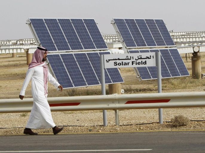 A Saudi man walks on a street past a field of solar panels at the King Abdulaziz city of Sciences and Technology, Al-Oyeynah Research Station in this May 21, 2012 file photo. Saudi Arabia's ambitious plans to become a world leader in installed solar power appear to have run into the sand amid disagreements over their scale, ownership and technology. The world's largest crude exporter announced three years ago it wanted to install 41 gigawatts of solar electricity by 2