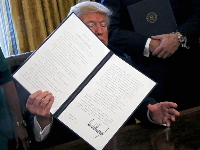 US President Donald J. Trump poses after signing an executive order in the Oval Office of the White House, in Washington, DC, USA, 03 February 2017. Trump signed several executive orders including an order to review the Dodd-Frank Wall Street to roll back financial regulations of the Obama era.