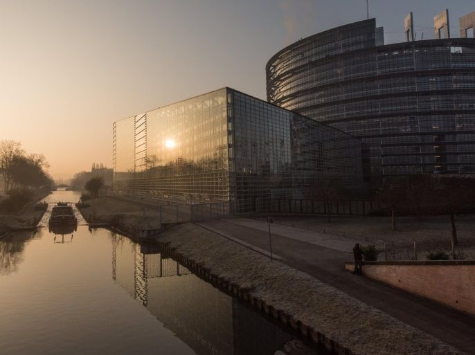 A cargo ship drives by the European Parliament in the sunrise in Strasbourg, France, 15 February 2017.