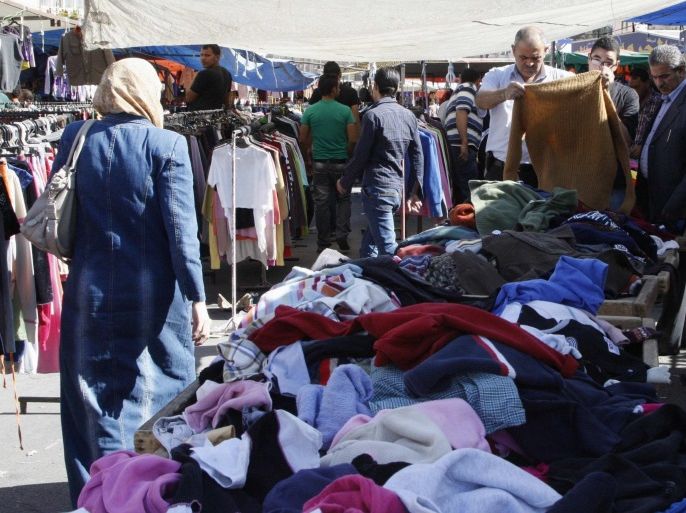 People look at second-hand clothes for sale at a public market during a shopping spree before the Eid al-Adha holiday, in Amman October 11, 2013. Picture taken October 11, 2013. REUTERS/Majed Jaber (JORDAN - Tags: RELIGION BUSINESS)