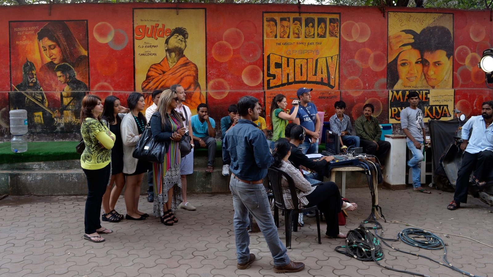 سواح أجانب يتابعون تصوير خارجي لفيلم سينمائي هندي (الجزيرة)