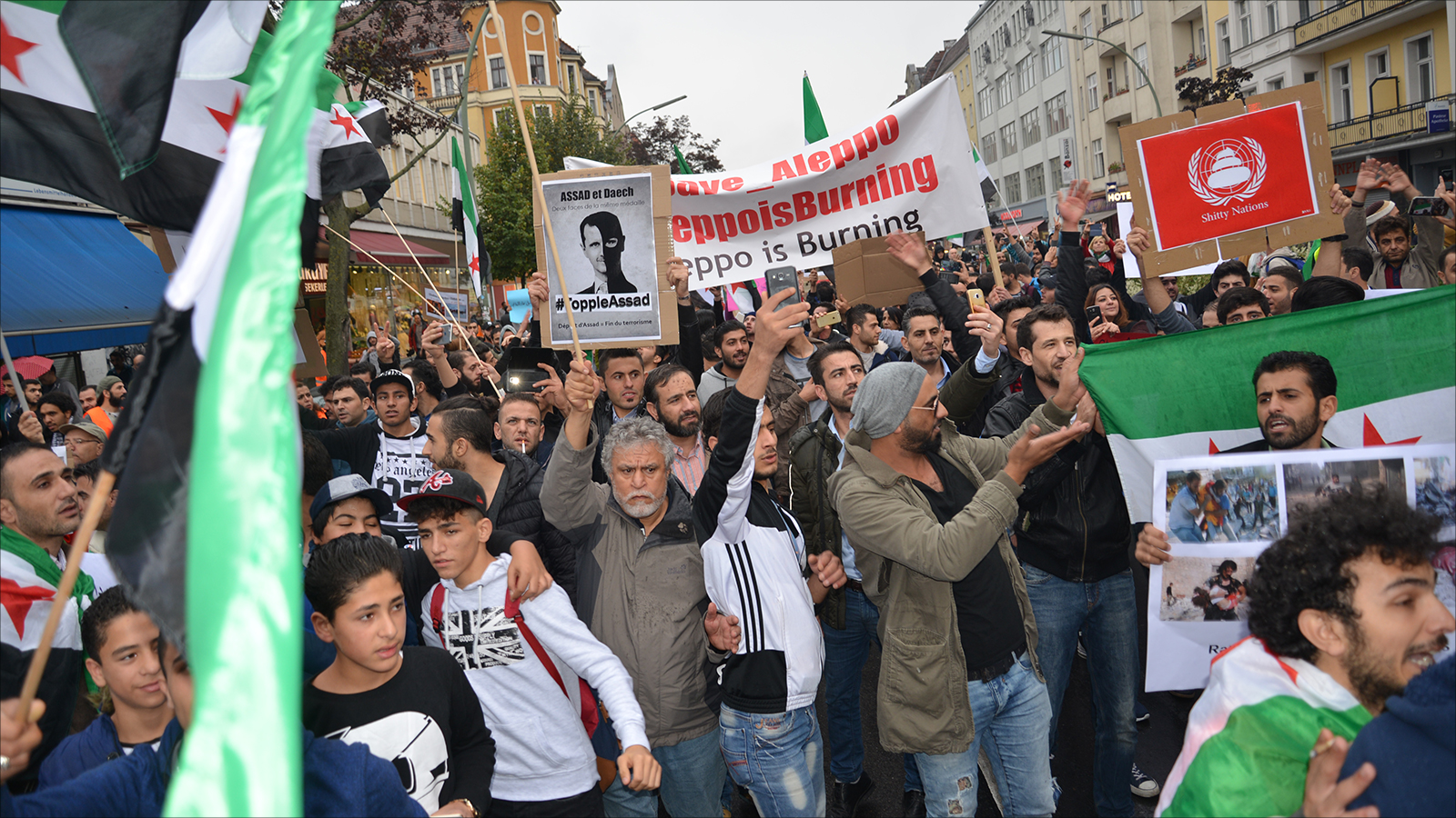 ‪لاجئون سوريون يرفعون بمظاهرة في برلين لافتات تطالب بجلب الأسد لمحكمة الجنايات الدولية‬ لاجئون سوريون يرفعون بمظاهرة في برلين لافتات تطالب بجلب الأسد لمحكمة الجنايات الدولية (الجزيرة)