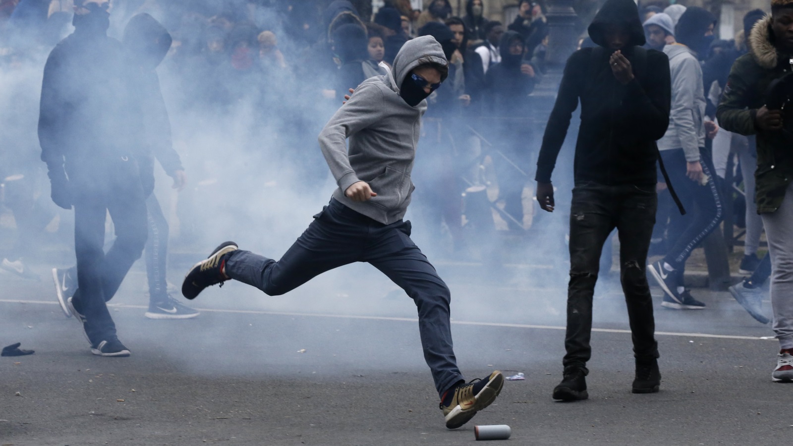 ‪محتج يحاول قذف قنبلة مدمعة أطلقتها الشرطة لتفريق متظاهرين يحتجون على اغتصاب شاب أسود‬ (رويترز)