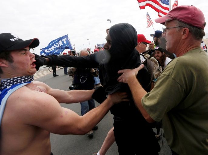 A pro-Trump rally participant is punched in the face by an anti-Trump protester as the two sides clash at a Pro-Trump rally in Huntington Beach, California, U.S., March 25, 2017. REUTERS/Patrick T. Fallon TPX IMAGES OF THE DAY