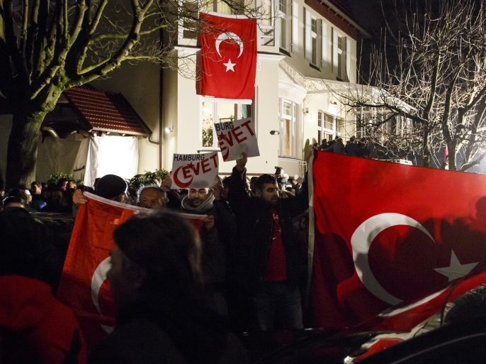 HAMBURG, GERMANY - MARCH 07: Supporters wave flags as Turkish Foreign Minister Mevlut Cavusoglu emerges from the Turkish consulate after speaking to supporters of the upcoming referendum in Turkey on March 7, 2017 in Hamburg, Germany. Turkish government officials have been speaking to expatriate Turks across Germany to rally support for a 'yes' in the upcoming referendum that would give Turkish President Recep Tayyip Erdogan broader powers. German authorities have int