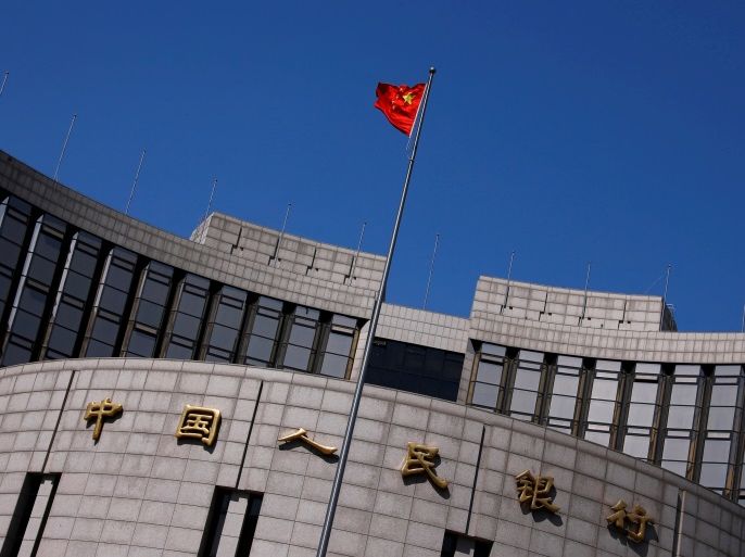 FILE PHOTO: A Chinese national flag flutters outside the headquarters of the People's Bank of China, the Chinese central bank, in Beijing, China April 3, 2014. REUTERS/Petar Kujundzic/File Photo