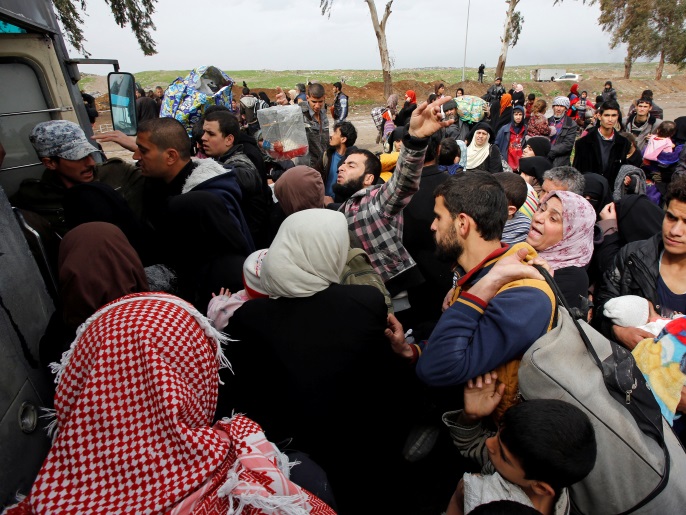 نازحون من الموصل شمالي العراق بانتظار نقلهم بالحافلات إلى منطقة آمنة (رويترز)