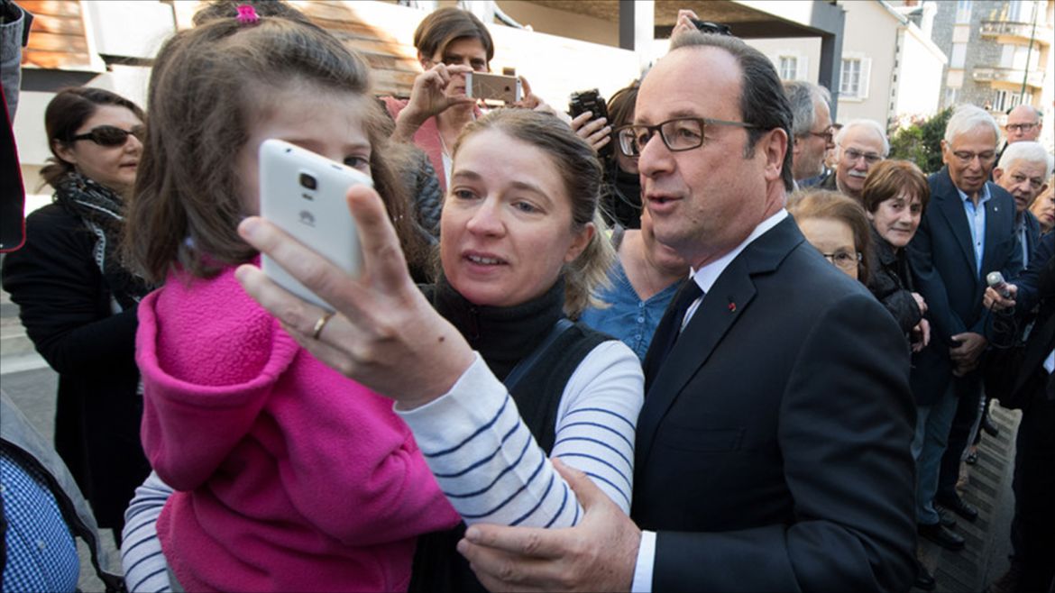 epa05922563 An unidentified supporter takes a selfie with French President Francois Hollande (R) as he leaves the polling station after voting in the first round of the French presidential elections 2017 in Tulle, central France, 23 April 2017.