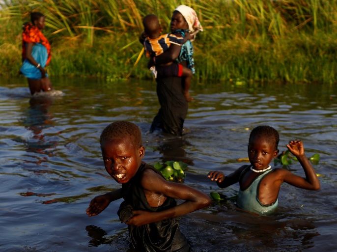 Children cross a body of water to reach a registration area prior to a food distribution carried out by the United Nations World Food Programme (WFP) in Thonyor, Leer county, South Sudan, February 25, 2017. Picture taken February 25, 2017. REUTERS/Siegfried Modola TPX IMAGES OF THE DAY