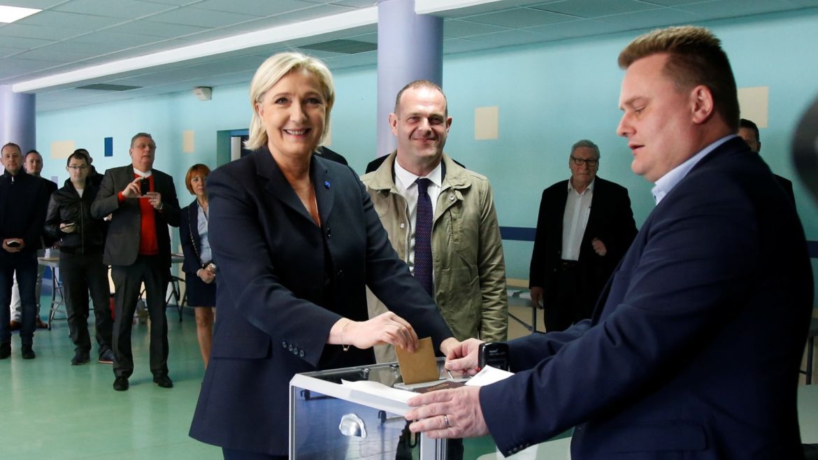 Marine Le Pen (L), French National Front (FN) political party leader and candidate for French 2017 presidential election, casts her ballot in the first round of 2017 French presidential election at a polling station in Henin-Beaumont, northern France, April 23, 2017. At C, Mayor of Henin-Beaumont Steeve Briois REUTERS/Charles Platiau