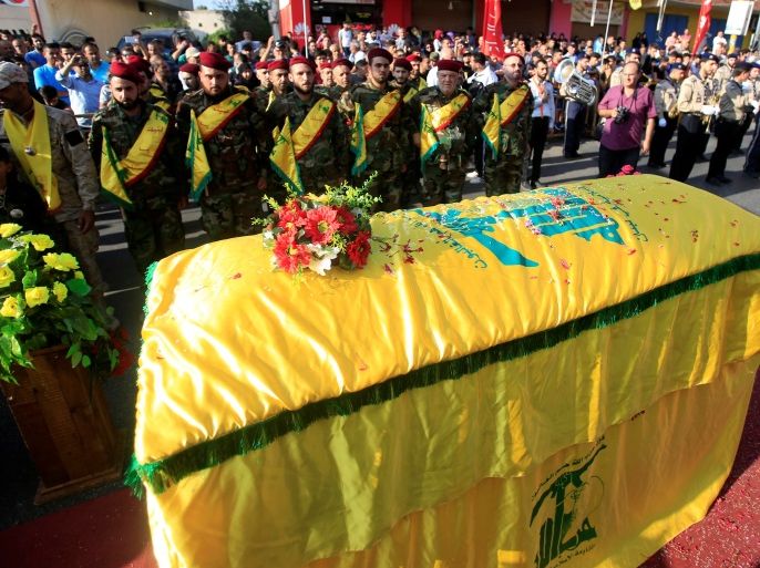 Lebanon's Hezbollah members stand at attention near the coffin of their comrade, Omar al-Obeid, who was killed fighting alongside Syrian army forces in Syria, during his funeral in Doueir village, near Nabatieh in southern Lebanon, July 5, 2016. REUTERS/Ali Hashisho