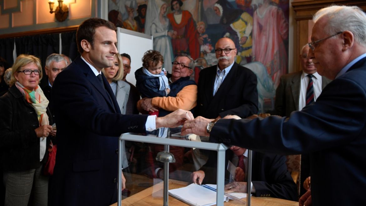 Emmanuel Macron (2ndL), head of the political movement En Marche !, or Onwards !, and candidate for the 2017 French presidential election, casts his ballot in the first round of 2017 French presidential election at a polling station in Le Touquet, northern France, April 23, 2017. REUTERS/Eric Feferbert/Pool