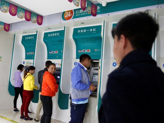 People use bank machine in a branch of the Agricultural Bank of China in the town of Nansan, Yunnan province, China, March 12, 2017. REUTERS/Thomas Peter