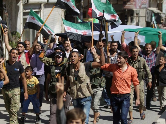 Rebel fighters and civilians carry opposition flags and chant slogans as they take part in a protest to express solidarity with the Free Syrian Army and the people of Aleppo, in the Syrian town of Azaz, September 27, 2016. REUTERS/Khalil Ashawi