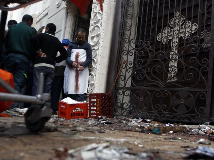 Egyptian Christians gather outside the Coptic Orthodox church after a car bomb attack, in Egypt's northern city of Alexandria, 230 km (140 miles) north of Cairo January 1, 2011. The car bombing outside the church killed 21 people as worshippers gathered to mark the New Year, security and medical sources said on Saturday. REUTERS/Amr Abdallah Dalsh (EGYPT - Tags: RELIGION CIVIL UNREST POLITICS)