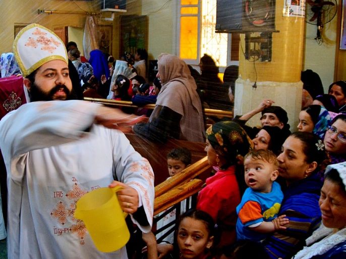 A Coptic Christian priest blesses his congregation with holy water during Sunday service in the Virgin Mary Church at Samalout Diocese in Al-Our village, in Minya governorate, south of Cairo, May 3, 2015. Copts have long complained of discrimination under successive Egyptian leaders and Sisi's actions suggested he would deliver on promises of being an inclusive president who could unite the country after years of political turmoil. However, striking out at extremists abroad might prove easier than reining in radicals at home. Orthodox Copts, the Middle East's biggest Christian community, are a test of Sisi's commitment to tolerance, a theme he often stresses in calling for an ideological assault on Islamist militants threatening Egypt's security. Picture taken May 3, 2015. To match story EGYPT-CHRISTIANS/SISI REUTERS/Stringer
