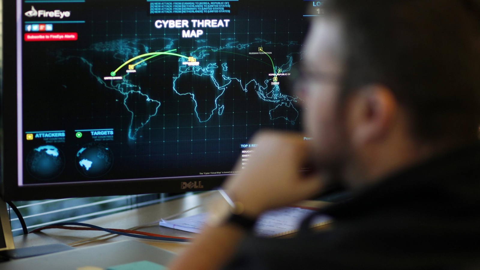 مهندس أمام شاشة تعرض خريطة بالتهديدات الإلكترونية عبر العالم (رويترز-أرشيف)