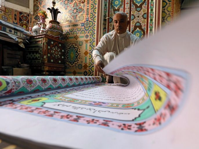 Saad Mohammed turns the page of a book he's handwritten at his studio, in the town of Belqina, north of Cairo, Egypt April 26, 2017. Picture taken April 26, 2017. REUTERS/Mohamed Abd El Ghany