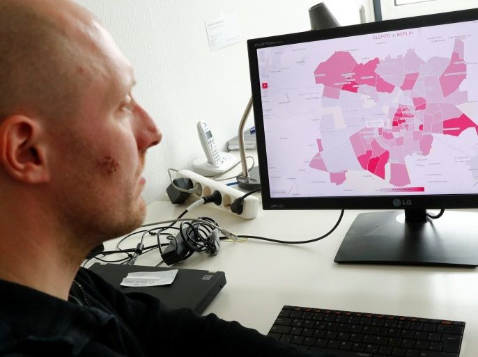 Data visualiser Hans Hack poses at his desk in front of a computer screen showing Aleppo's destruction projected on a Berlin map, in Berlin, Germany May 3, 2017. Picture taken May 3, 2017. REUTERS/Fabrizio Bensch