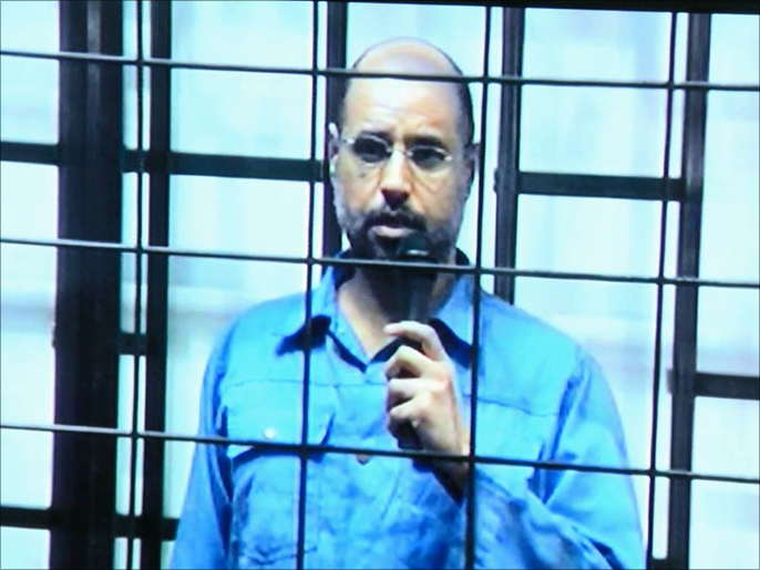 ‪سيف الإسلام يظهر عبر دائرة تلفزيونية مغلقة من الزنتان بإحدى جلسات المحاكمات بطرابلس‬ (الجزيرة)