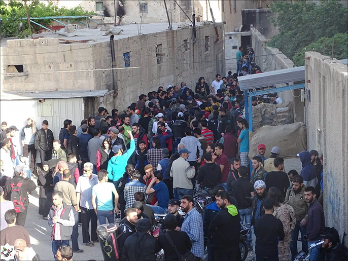 ‪المقاتلون وعائلاتهم ينتظرون حافلات للخروج من حي برزة بدمشق إلى إدلب‬ (ناشطون-أرشيف)