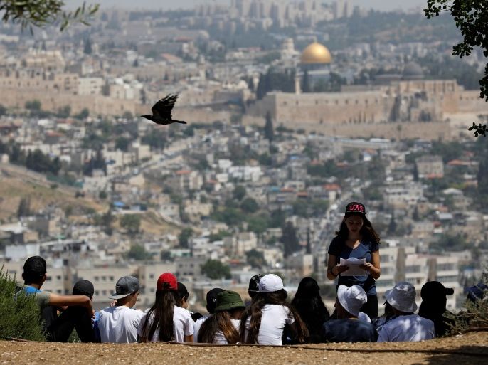 A crow flies past as Jewish school children gather at a look-out point on the Armon Hanatziv Promenade in Jerusalem May 11, 2017. Picture taken May 11, 2017. REUTERS/Amir Cohen