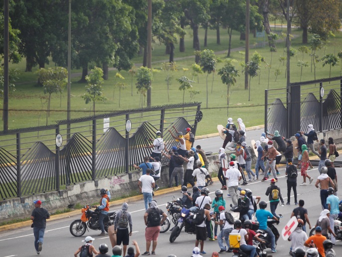 متظاهرون يحطمون جزءا من سياج قاعدة فرانشيسكو دي ميرندا الجوية بكراكاس قبل أن تطردهم الشرطة 