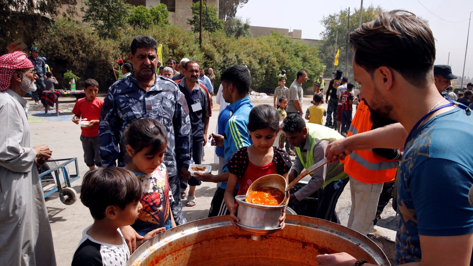 توزيع طعام على سكان غربي الموصل بعد توقف الحرب في حي الطيران (رويترز)