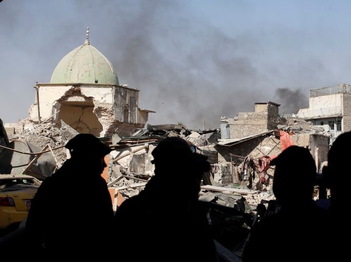 Members of Iraqi Counter Terrorism Service and the media are silhouetted in front of the ruins of Grand al-Nuri Mosque at the Old City in Mosul, Iraq June 29, 2017. REUTERS/Erik De Castro