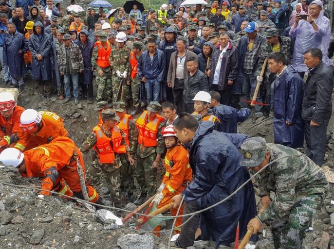 People search for survivors at the site of a landslide in Xinmo Village, Mao County, Sichuan province, China June 24, 2017. China Daily via REUTERS ATTENTION EDITORS - THIS IMAGE WAS PROVIDED BY A THIRD PARTY. CHINA OUT. NO COMMERCIAL OR EDITORIAL SALES IN CHINA.