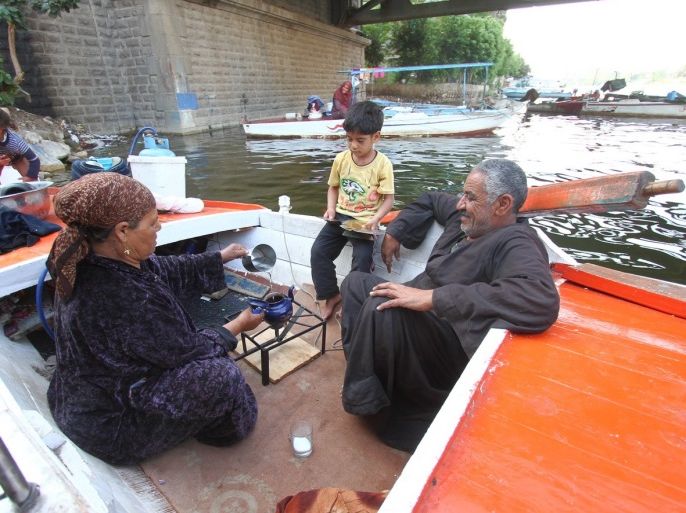 الصياد العجوز يشرب الشاي مع زوجته على متن قاربهما أو مسكنهما