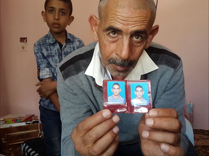 فلسطين رام الله كوبر 22 تموز 2017 والد منفذ عملية حلميش عمر العبد يحمل صورة له.