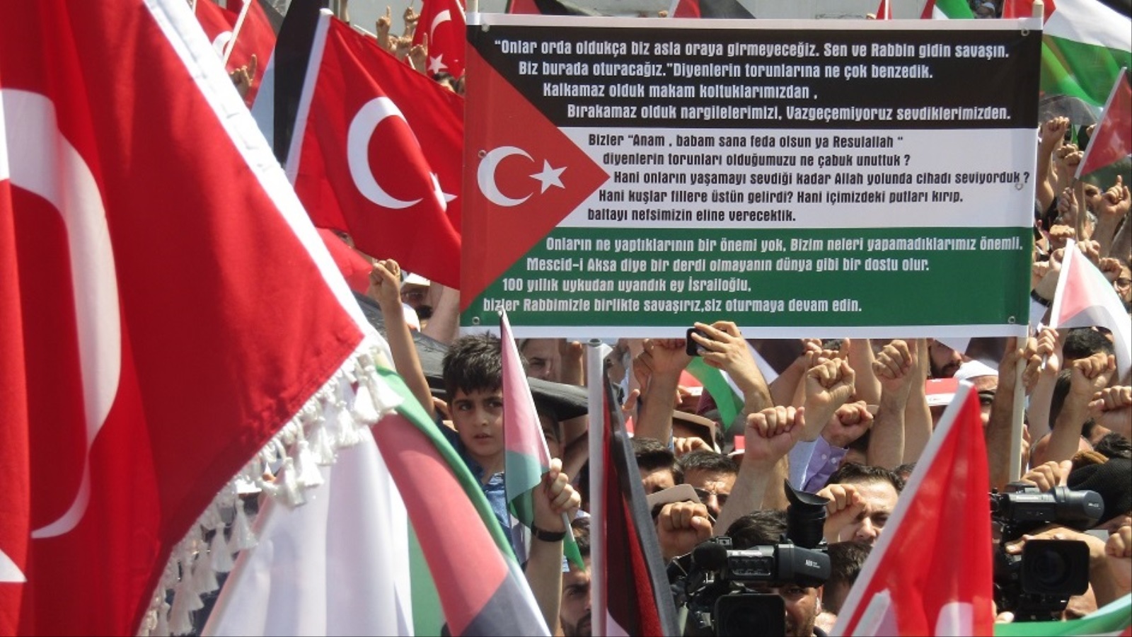 أتراك يرفعون علما فلسطينيا يحتوي نجمة العلم التركي وهلاله خلال وقفة الغضب للأقصى بإسطنبول (الجزيرة)