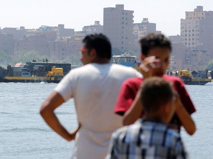 People look at Egyptian riot police leave on a ferry after clashes with residents of the Nile island of al-Warraq, when security forces attempted to demolish illegal buildings, in the south of Cairo, Egypt July 16, 2017. REUTERS/Amr Abdallah Dalsh