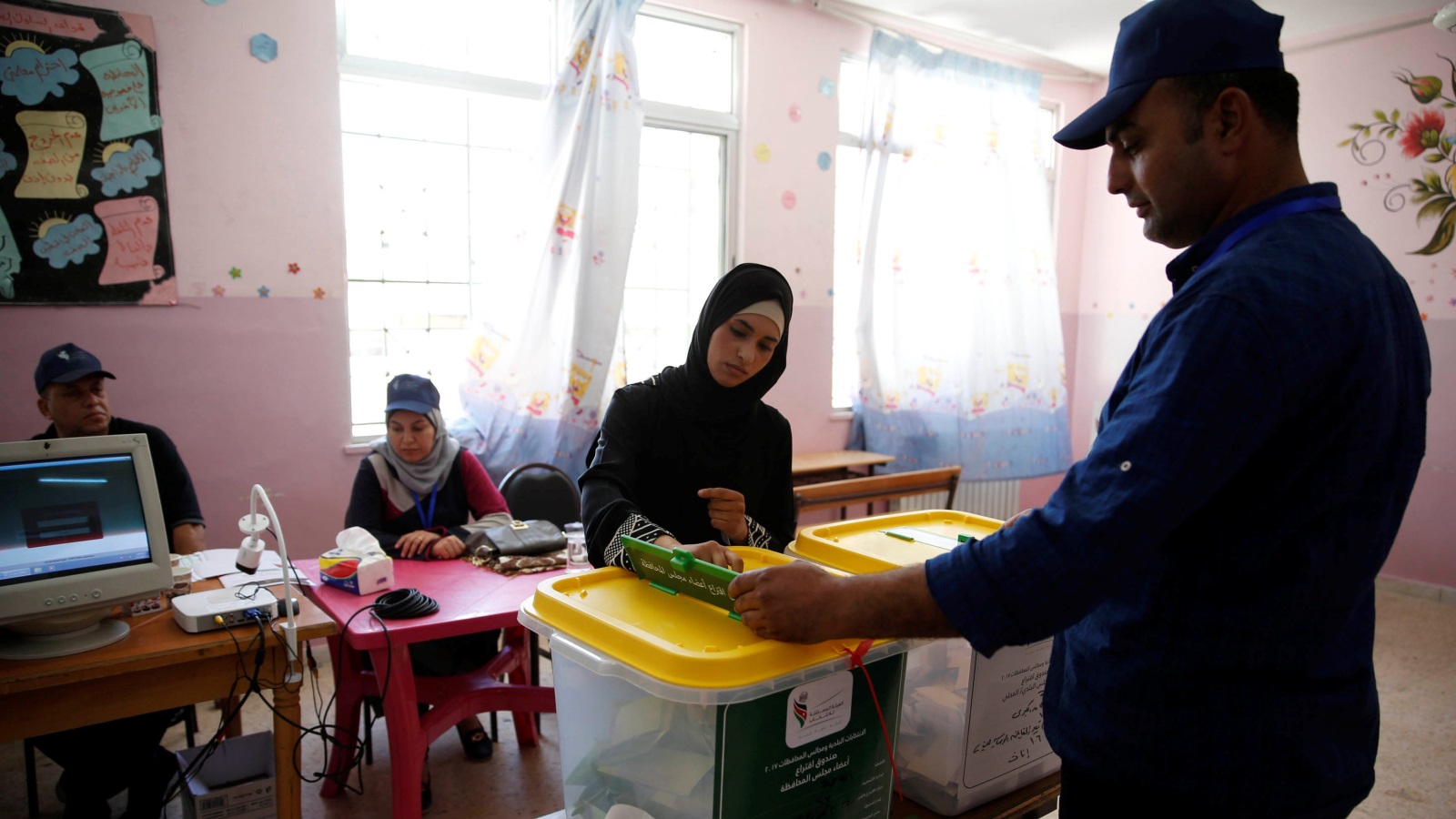 سيدة أردنية تدلي بصوتها في أحد مراكز الاقتراع بالعاصمة عمان (رويترز)