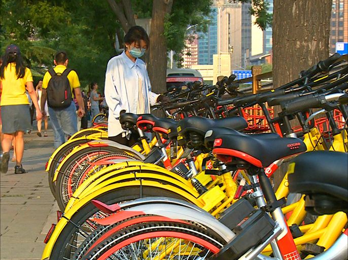 فتاة صينية تستخدم دراجة تشاركية