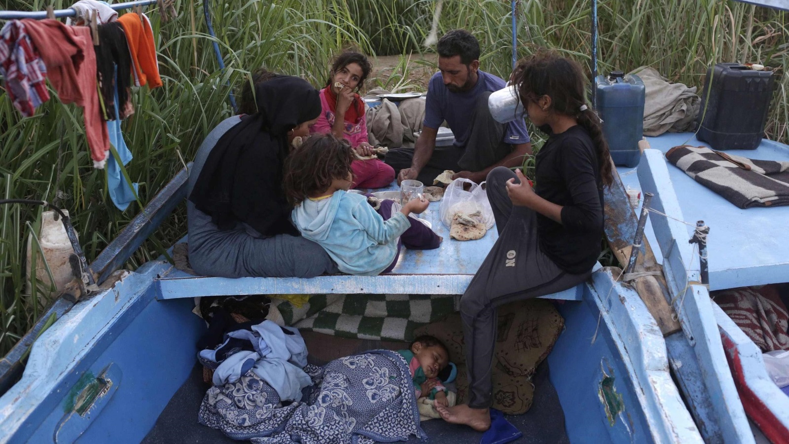 عائلة تتناول إفطارها في قاربها الذي تعيش فيه  (رويترز)