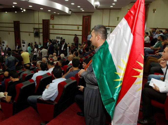 A Kurdish man holds a kurdish flag inside the Council of the Governor of Kirkuk in Kirkuk, Iraq August 29, 2017. REUTERS/Ako Rasheed