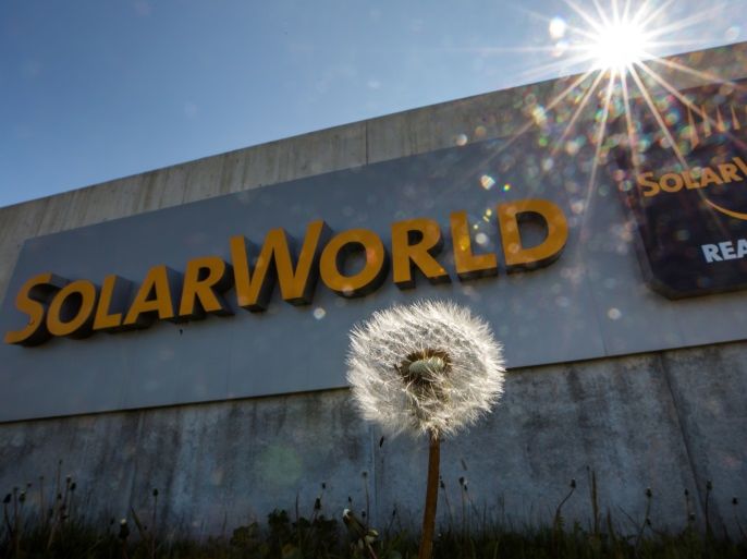 A dandelion is pictured in front of the sign of the German manufacturer of solar panels Solarworld at its plant in Arnstadt, eastern Germany on May 11, 2017.Solarworld announced its bankruptcy on May 10, 2017. / AFP PHOTO / dpa / arifoto UG / Germany OUT (Photo credit should read ARIFOTO UG/AFP/Getty Images)