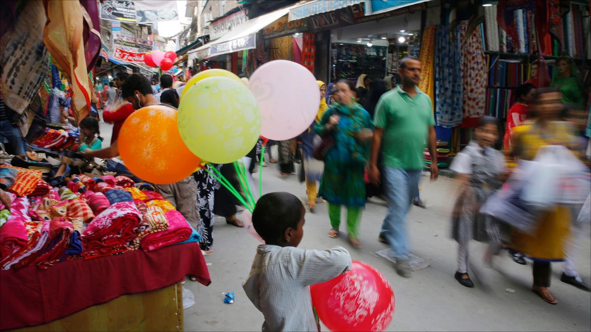 epa06174051 An Indian boy sells balloons by the roadside as Kashmiri Muslims shop ahead of the Eid al-Adha festival, in Srinagar, the summer capital Indian Kashmir, 31 August 2017. Kashmiri Muslims will celebrate Eid al-Adha on 02 September 2017 by sacrificing animals to commemorate God's gift of a ram to substitute for Abraham's impending sacrifice of his son and is considered one of the two most important holidays in the Islamic calendar.  EPA-EFE/FAROOQ KHAN